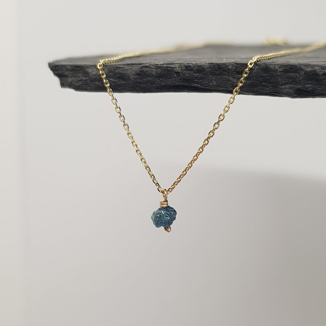 raw blue diamond necklace on 9ct yellow gold chain, displayed hanging from a black slate