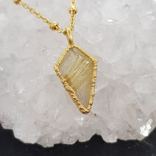 Load image into Gallery viewer, rutilated quartz rough diamond-shaped necklace set in 24ct gold with 45cm chain, handmade in the UK, displayed on a quartz stone
