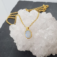 Load image into Gallery viewer, raw gold moonstone pebble necklace displayed on a crystal
