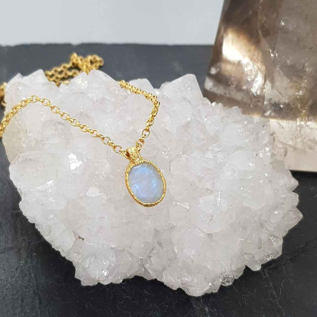 moonstone gold pebble necklace displayed on a crystal