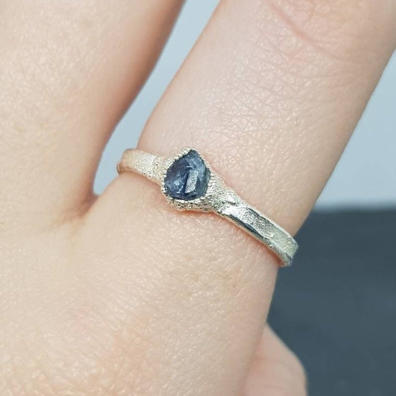 raw uncut blue sapphire ring on finger