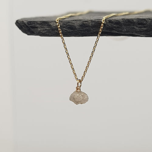 raw white diamond necklace on 9ct yellow gold chain, displayed hanging from a black slate